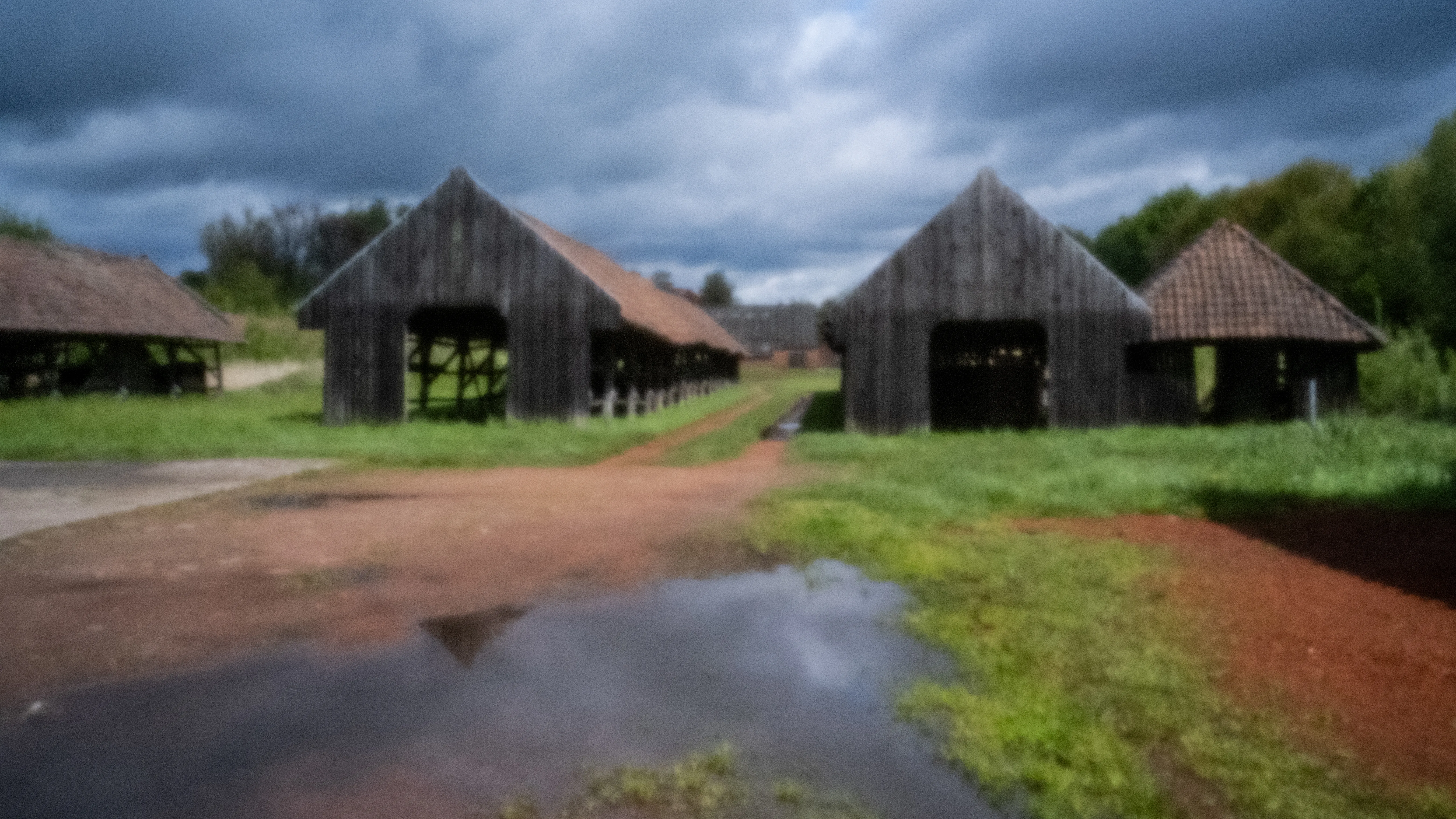 Wooden drying sheds of the brickworks under a dark cloudy sky