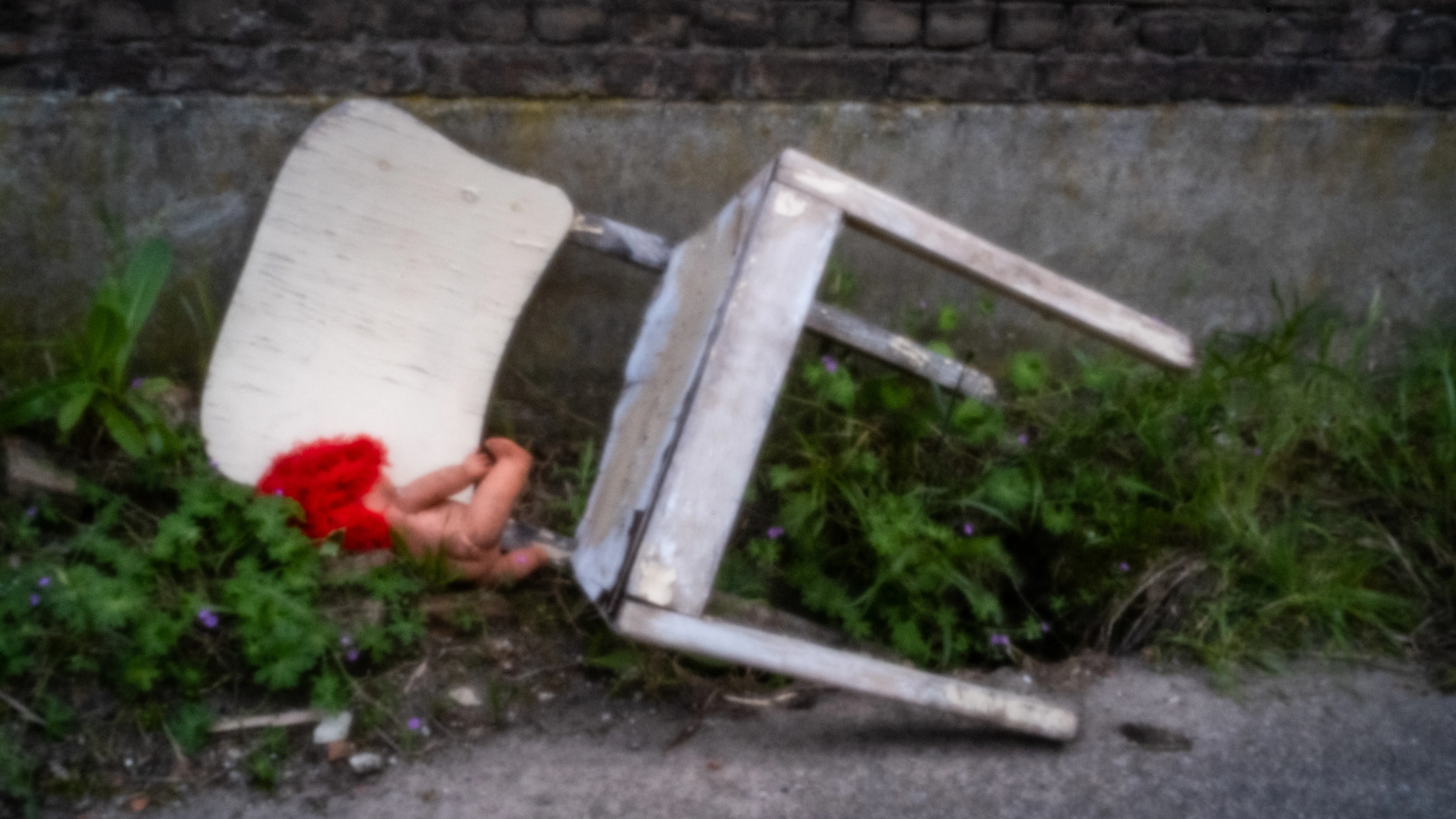 Toppled white chair with red flowers among the rubble