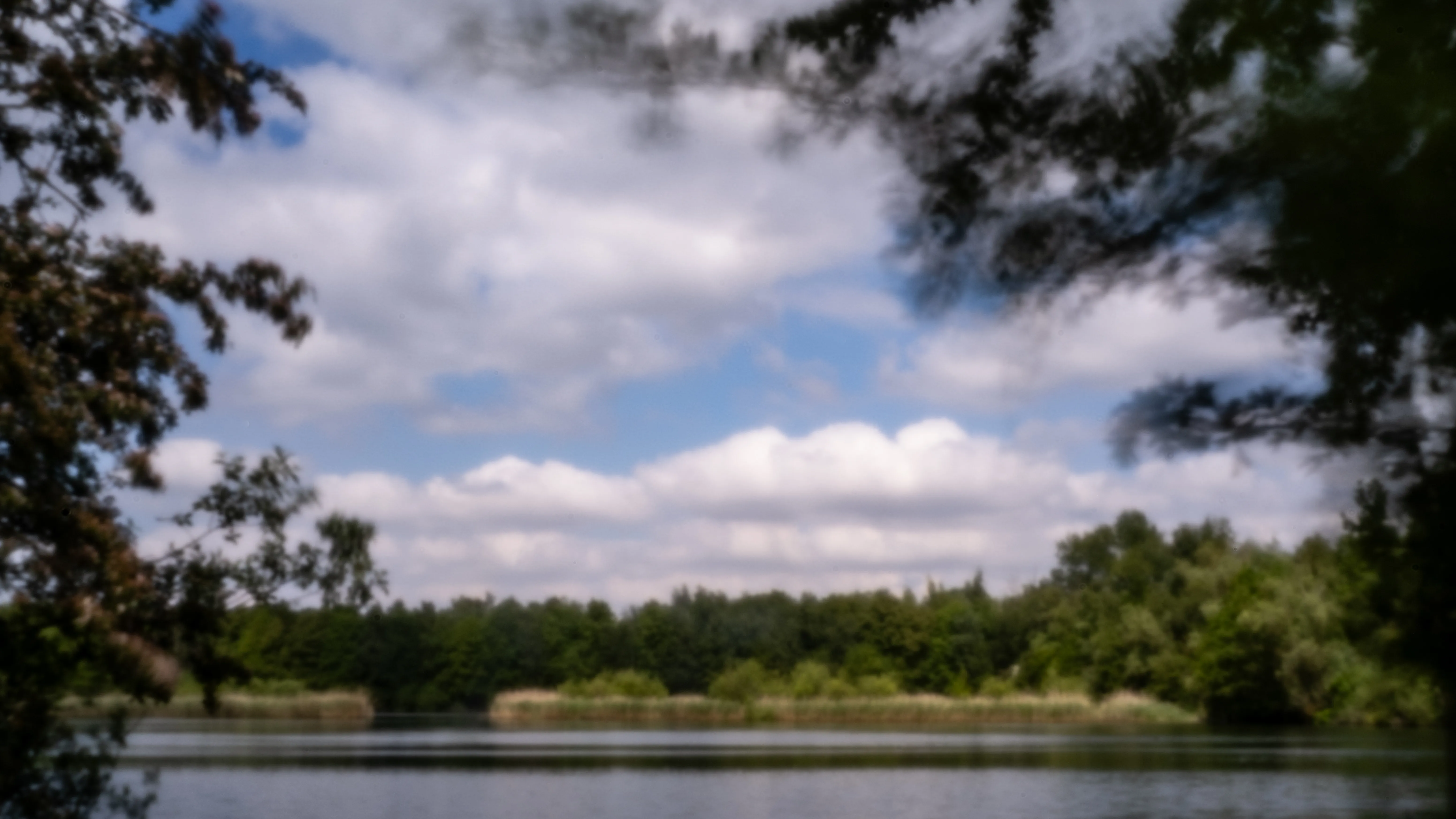 Cloudy sky above the water of a clay pit
