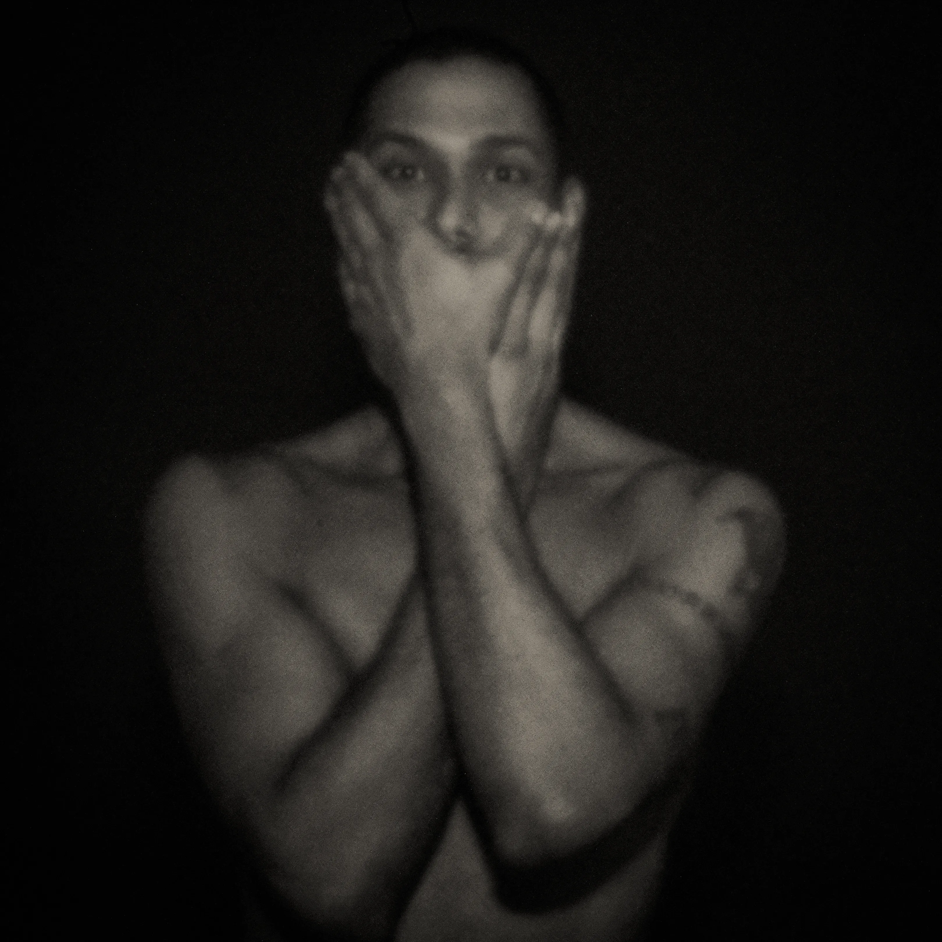 Pinhole-portret van een man die beide handen voor zijn mond houdt