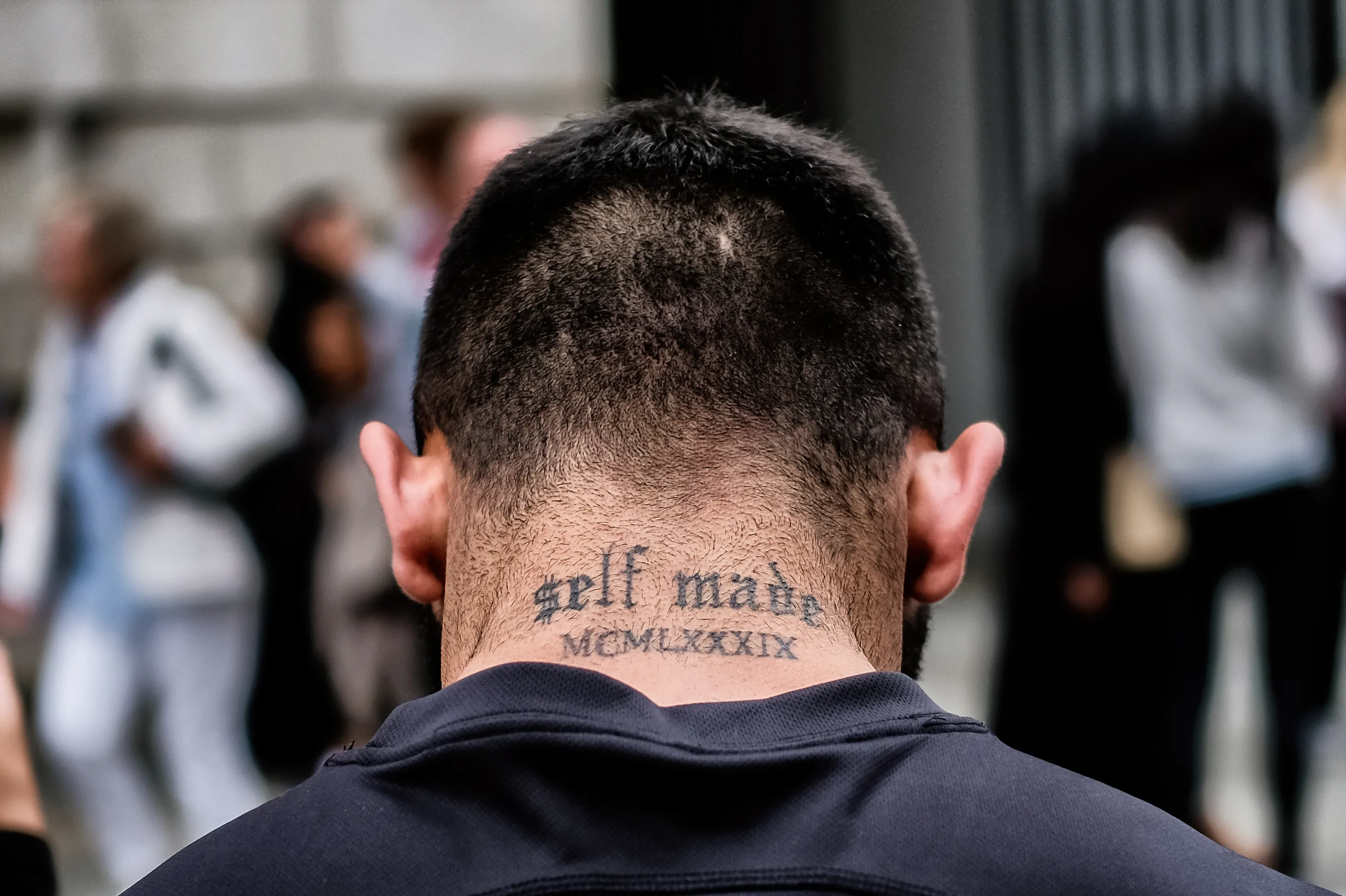 Back of a man’s head with the neck tattoo self made